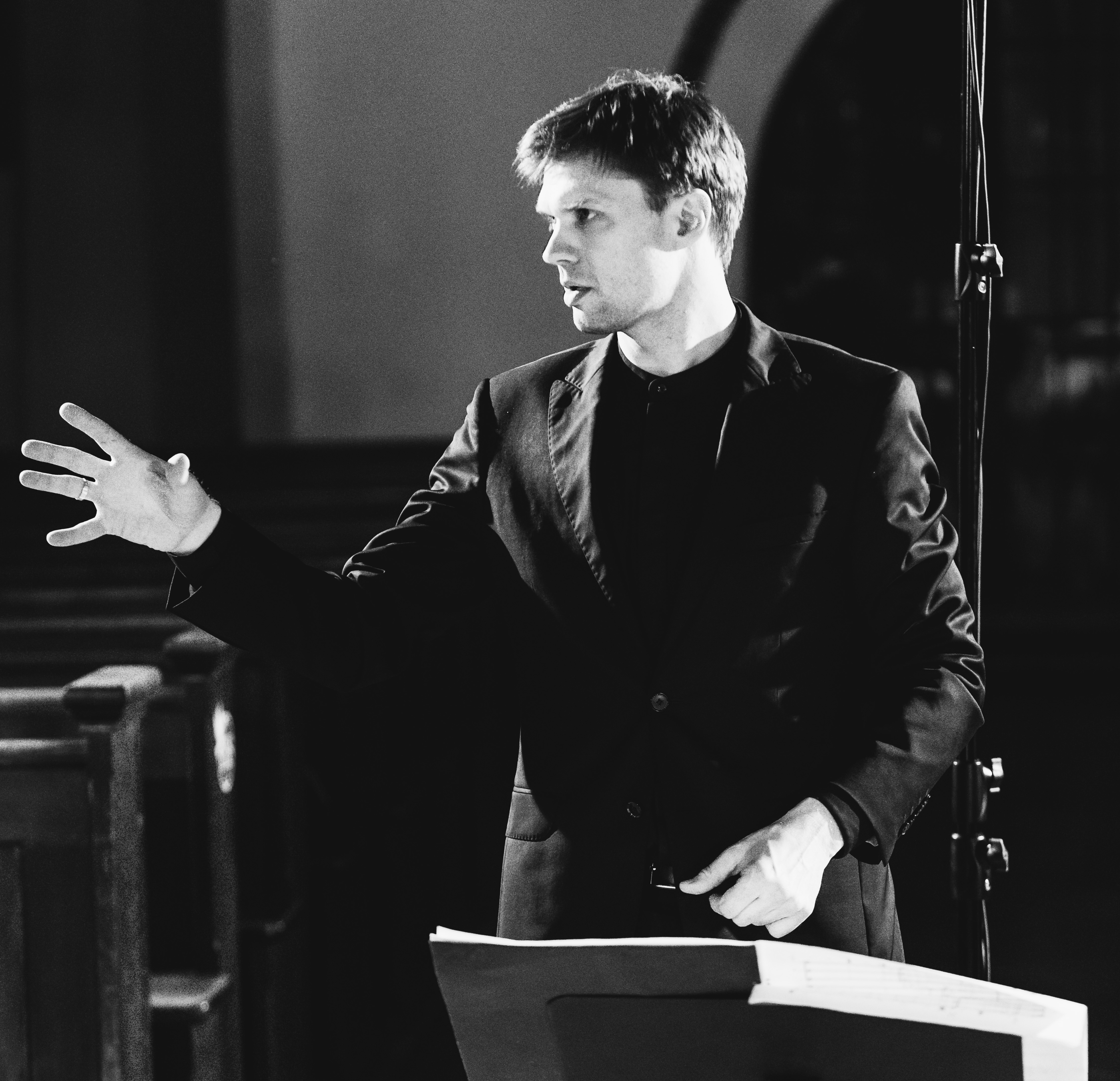 Jakub Szafrański dyrygujący chórem w kościele podczas sesji nagraniowej